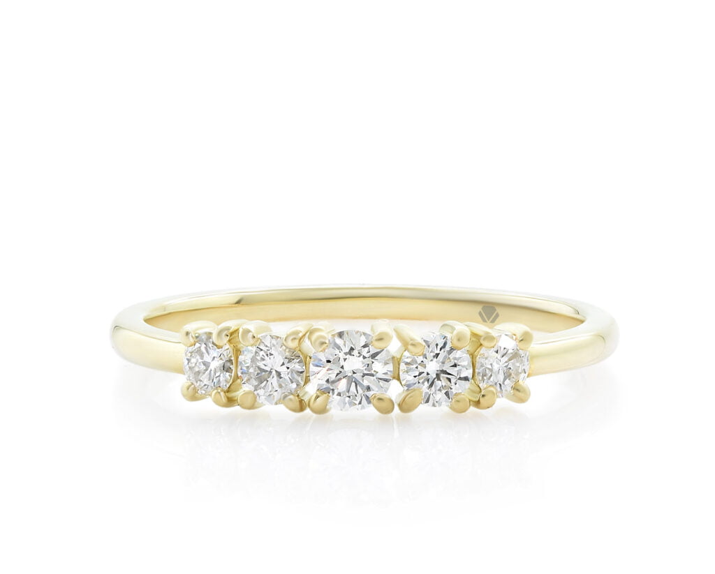 Cintillo Flair Oro Amarillo 18k con 1 Diamante brillante 10 pt, 2 Diamantes brillante 7 pt, y 2 Diamantes brillante 5 pt