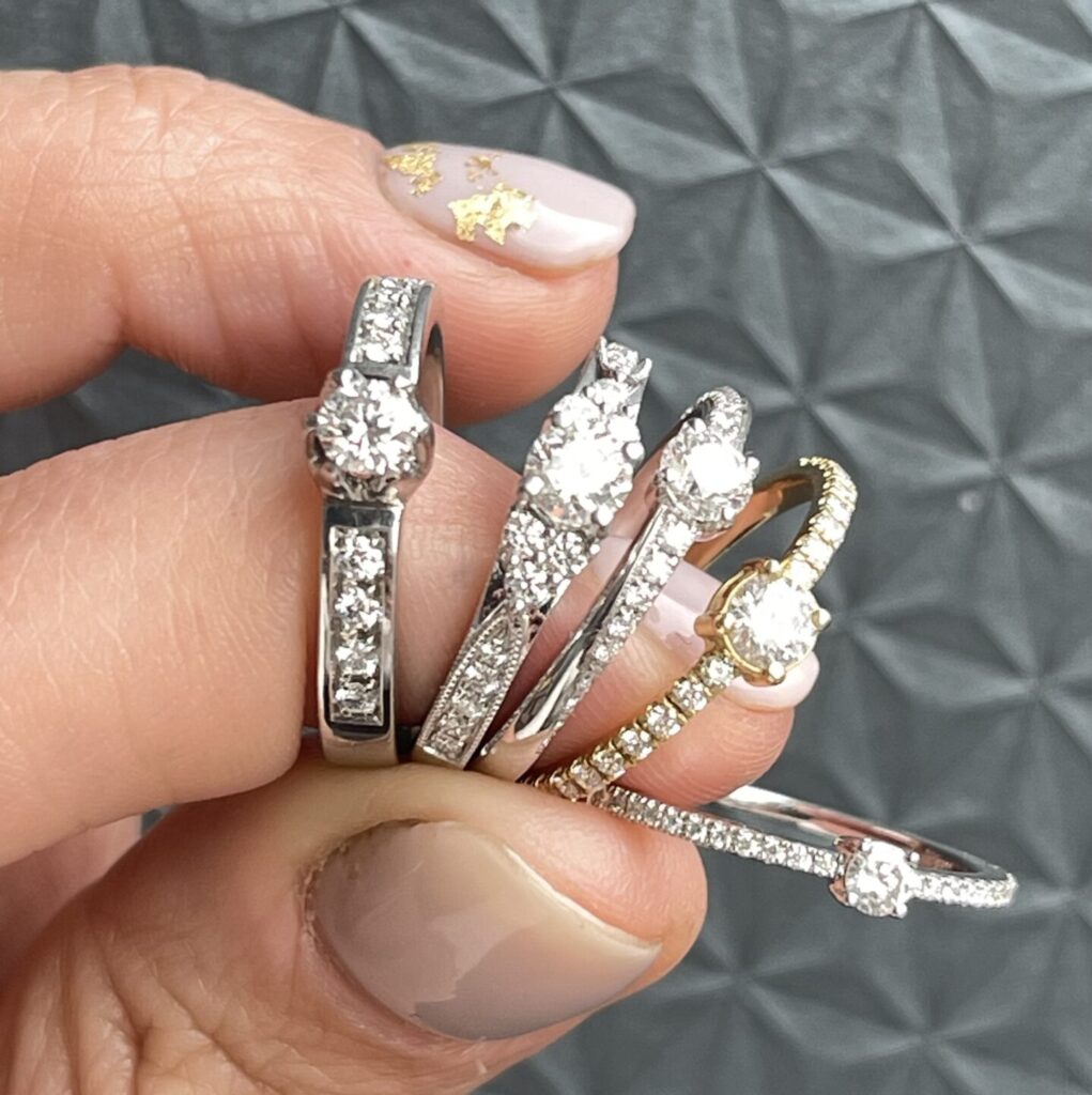 diferentes estilos de anillos de compromiso comparados en la mano