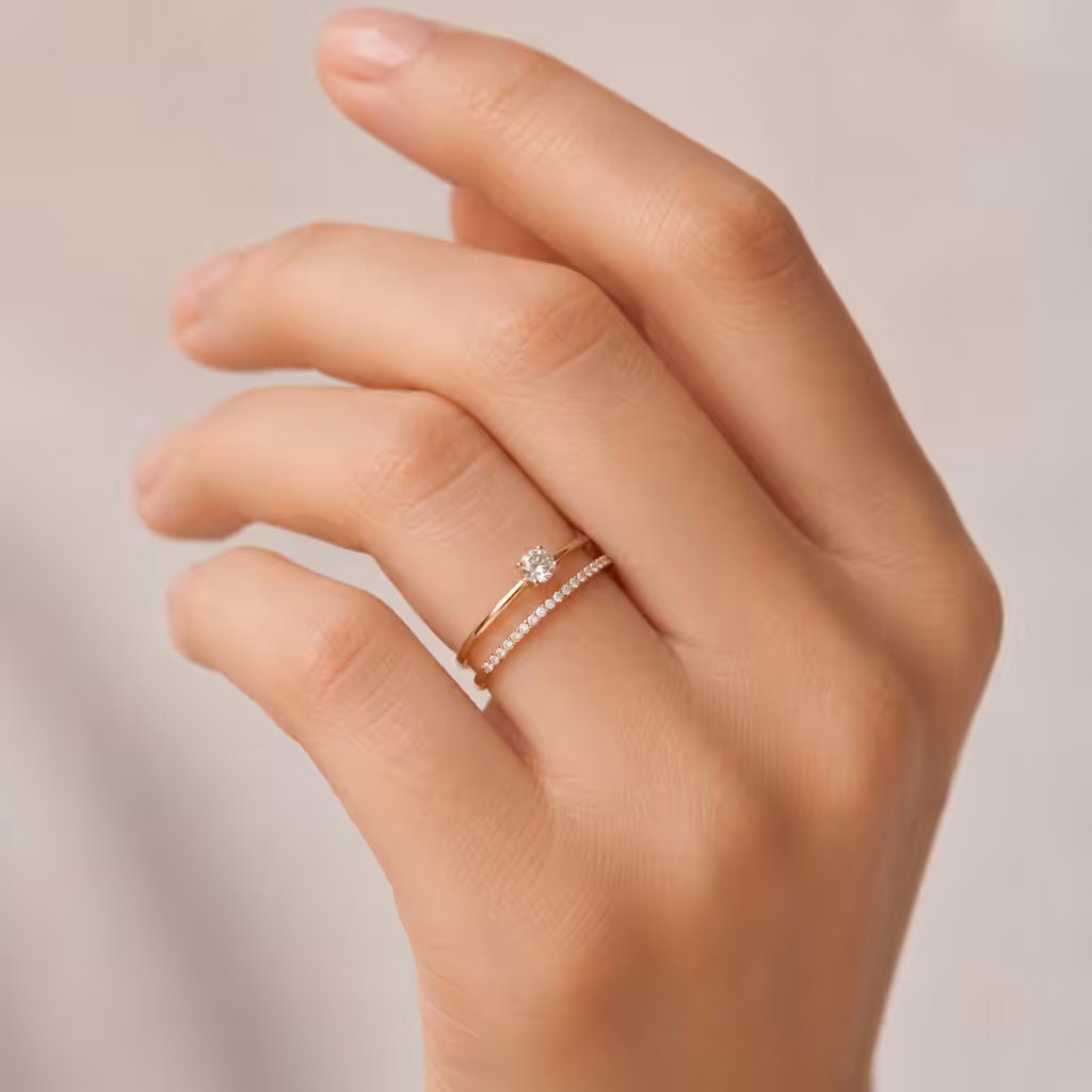 Mano pequeña con cintillo fino de diamantes y anillo delicado.