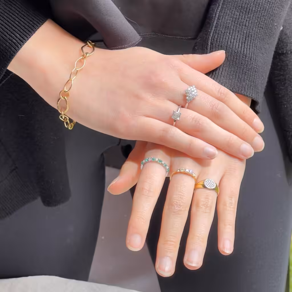Dos manos con anillos de diseños clásicos, geométricos y contemporáneos.