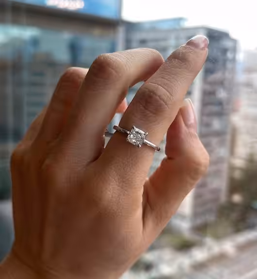 Anillo de compromiso con diamante visto en una mano en un entorno cotidiano