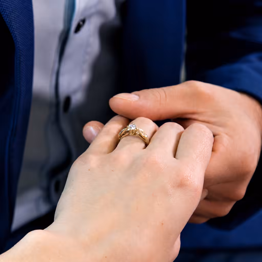 Anillo solitario clásico usado en una mano sostenida por otra persona