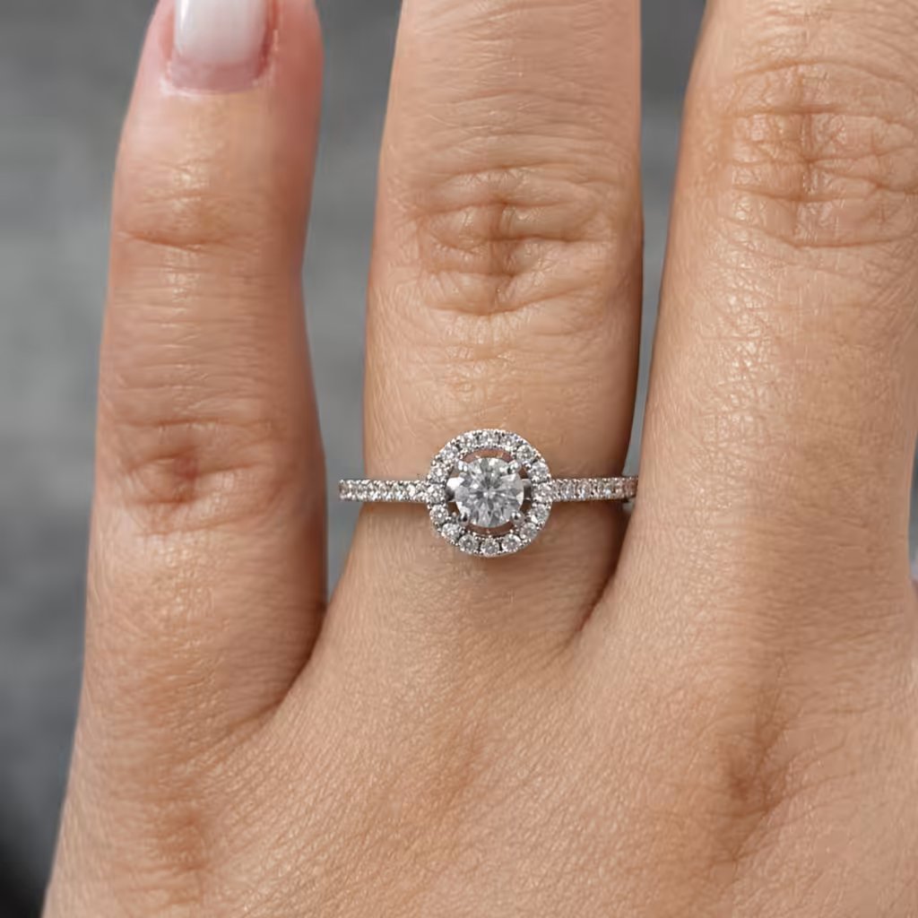 Anillo con diamante central, halo redondo y pavé sobre el aro