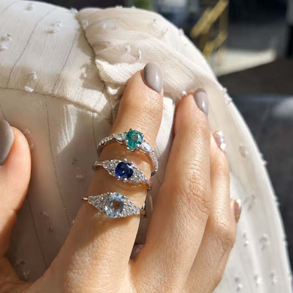 Anillos con esmeralda, zafiro y aguamarina en distintos tipos de engaste.