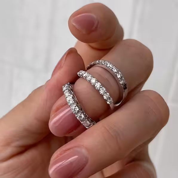 Tres cintillos de diamantes de distintos tamaños sostenidos en una mano
