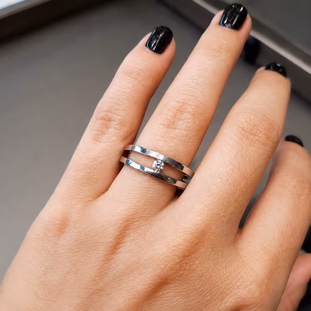 Anillo contemporáneo de doble banda con un diamante central pequeño.